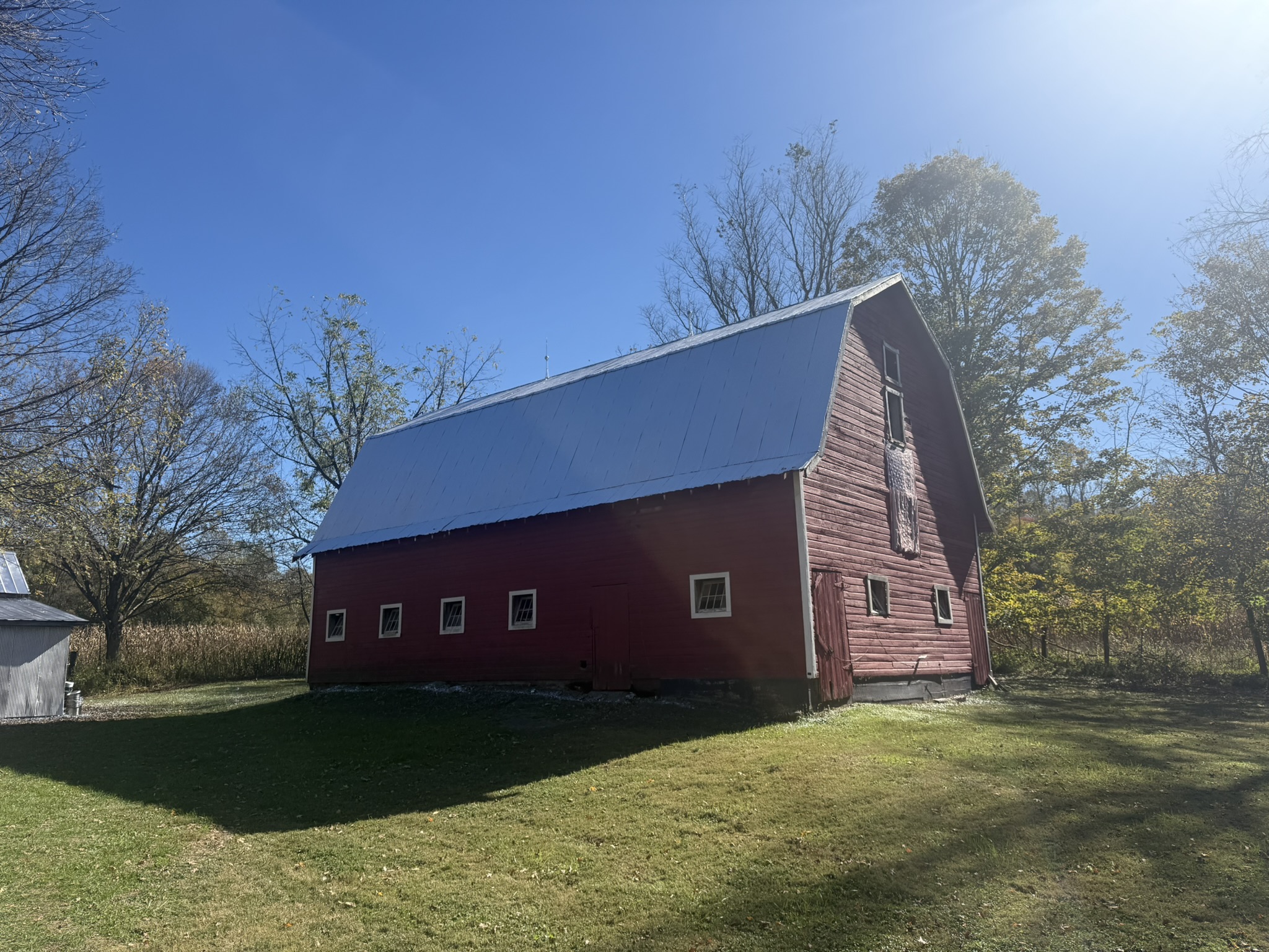 The red barn with autumn trees and blue sky